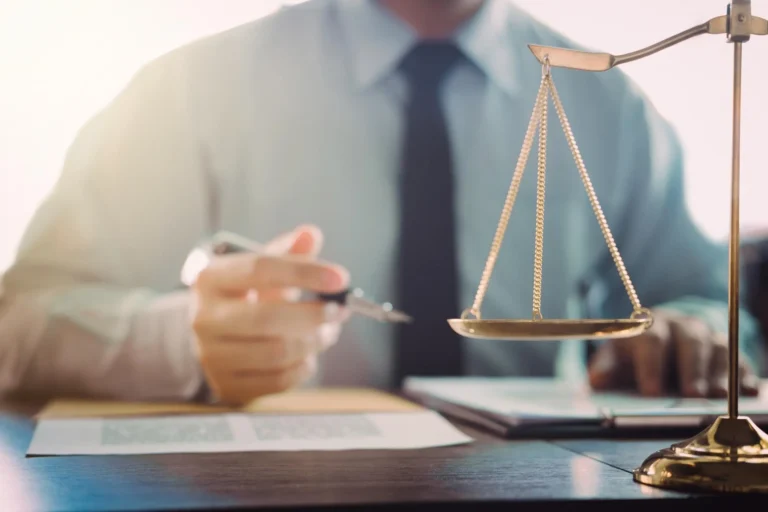 Abogado en su despacho con una balanza de la justicia